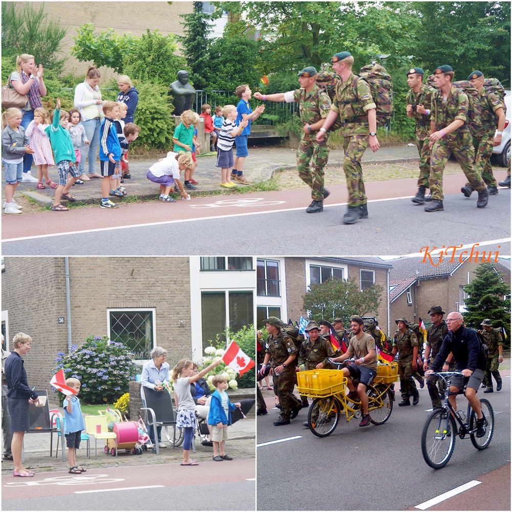 特別自世界各地來參與健行的軍人和黃色補給腳踏車；放著暑假的小朋友則忙著為行經的軍人們加油打氣